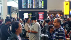 As pessoas fazem fila e esperam em um dos terminais do aeroporto de Heathrow.