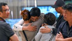 Pasajeros del turbulento vuelo SQ321 de Singapore Airlines se abrazan en el aeropuerto Changi de Singapur tras el aterrizaje del avión.
