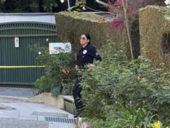 Una policía en una puerta de la casa de Rihanna