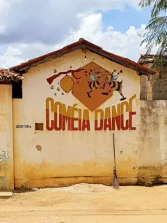 Fachada da discoteca Coméia Dance no Povoado de Abelhas, distrito de Inhobim, que pertence ao município de Vitória da Conquista - BA. A fachada inclui o nome da danceteria e o desenho de duas abelhas dançando ao lado de uma colmeia