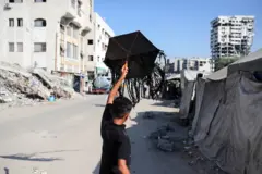 صبي يحاول أن يُطير طائرة ورقية في مخيم للنازحين في مدينة غزة في 23 أغسطس/آب 2026.