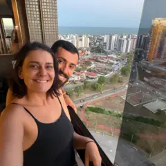 Rebeca e Ezequiel posam para uma foto da janela do apartamento deles em João Pessoa