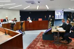 Bolsonaro sentado de frente para Moraes em sala de depoimento no STF