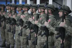 sırayla dizilmiş askerler silahlarını tutarken