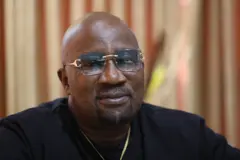 Baba Londoner - o wọ aṣọ dudu pẹlu igo loju rẹ ati ẹgba ọrun