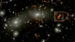 Alaknanda is located near the right centre of the image (see zoomed image in inset). The central portion of the image is dominated by bright galaxies of the Abell 2744 cluster. The cluster acts as a gravitational lens and magnifies (and in some cases, distorts) galaxies lying in the background. Alaknanda is magnified by a factor approximately two, making this faint galaxy easier to detect.