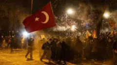 市長拘束に抗議するデモ隊。トルコの国旗が掲げられている
