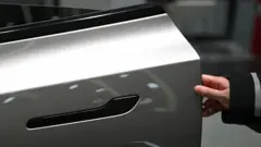 Женщина открывает дверь электромобиля Tesla Model Y в автосалоне в Пекине 3 февраля 2026 года.