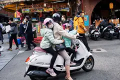 台北一位母亲骑摩托车载着两名子女