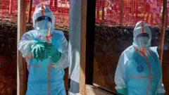 የጤና ባለሙያዎች በዲሞክራቲክ ኮንጎ፣ ኢቱሪ ግዛት ለተከሰተው የኢቦላ በሽታ ምላሽ ለመስጠት የበሽታ መከላከያ አልባሳትን ለብሰው ይታያሉ። 