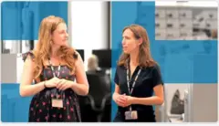 Two female colleagues walk together in conversation.