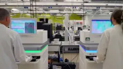 Two back scientists to two high -tech white sequencer.