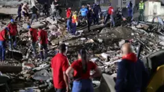 Responders search for victims in a demolished building at San Bernardino after a magnitude 7.2 earthquake struck Venezuela and other regions in the Caribbean on June 24, 2026 in Caracas, Venezuela.