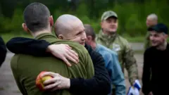 Мужчины обнимаются, у одного из них в руке яблоко