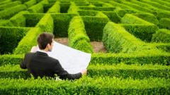 Homem olha para labirinto segurando mapa