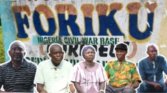 A man wey dey wear cloth wey get white stripes, anoda man wey dey wear polo looking straight, a woman wearing scarf looking sad, a man wit cap on im head wearing a pattern cloth and anoda man wey dey look straight.