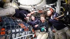 Orion kapsülünün içinde dört astronot, en soldakinin elinde mikrofon var. 