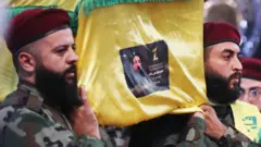 Hezbollah fighters carry the coffin of commander Fuad Shukr during his funeral in the southern suburbs of the Lebanese capital Beirut 1 on 2024