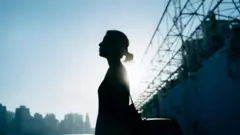 በጥላ ተሸፍና ፊቷ የማይታይ ሴት 
