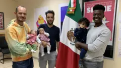 Phillip Lühl, Guillermo Delgado y un amigo de la pareja cargando a las gemelas, Paula and Maya, y a Yona.