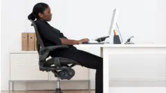 Femme assise devant son bureau