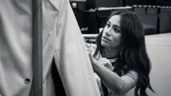 Meghan revisa algunas prendas de ropa.