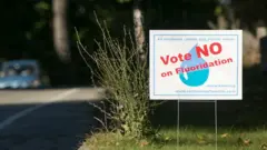 Un letrero pidiendo que se vote en contra del flúor en el agua