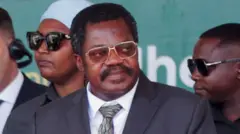 Tanzania Vice-President Emmanuel Nchimbi wear black suit and white shirt as e attend di inauguration of hydropower project for Rufiji