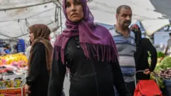 Pazarda alışveriş yapan bir Suriyeli kadın