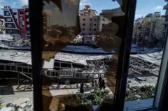 يمرّ الناس بجوار الأنقاض في موقع غارة إسرائيلية أعقبت اتفاقاً بين الولايات المتحدة وإيران في صور، جنوب لبنان، 16 يونيو/حزيران 2026.