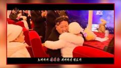 Kim Jong Un abrançando criança em transmissão de TV