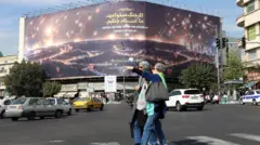 امرأتان تسيران في أحد الشوارع الإيرانية وتبدو الحياة طبيعية 