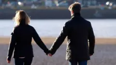 زوجان في منتصف العمر يمسكان أيدي بعضهما، ديفون، المملكة المتحدة. 