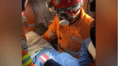 عامل الإطفاء فيل إيرفينغ خلال إنقاذه شخصين من ركام الزلزال في تركيا