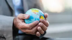 Homem segurando globo representando o planeta