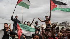 যুদ্ধবিরতির খবর আসার পর ফিলিস্তিনের পতাকা নিয়ে গাজার কিছু মানুষের উল্লাস