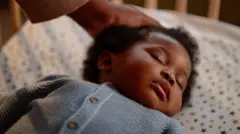 Bebê dormindo de costas em um berço