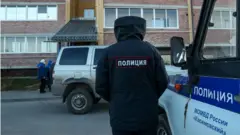 A policeman at the scene of the shooting in the village of Yelatma, Russia