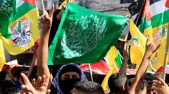 فلسطينيون يلوحون بالأعلام الفلسطينية وأعلام حركتي حماس وفتح خلال مسيرة تضامن مع غزة، في نابلس 26 أكتوبر/ تشرين أول 2023