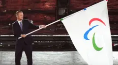 IPC President Andrew Parsons hands over the Paralympic flag during the closing ceremony of the Paris 2024 Summer Paralympic Games at the Stade de France, Paris