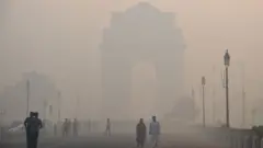 Indian pedestrians walking near the India Gate monument amid heavy smog in New Delhi on October 20, 2017