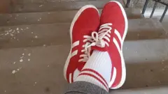 ቀይ ጫማ ያደረገ እግር