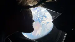 La astronauta Christina Koch mira la Tierra desde la nave Artemis II