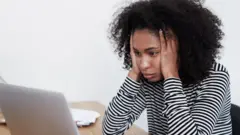 Femme regardant son ordinateur portable avec frustration