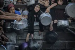 Un grupo de mujeres palestinas esperan agolpadas en Gaza a que les entreguen ayuda humanitaria.
