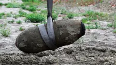 The unexploded bomb is removed from the river bed