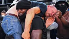 Hutchinson, que é negro, carrega manifestante branco em meio a protesto