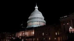 暗い夜空を背に、建物内の一部に明かりがついた米連邦議会議事堂
