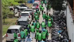 The motorcycle taxi drivers walking towards the hospital