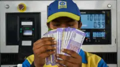 पेट्रोल पंप पर तेल गिरता एक कर्मी